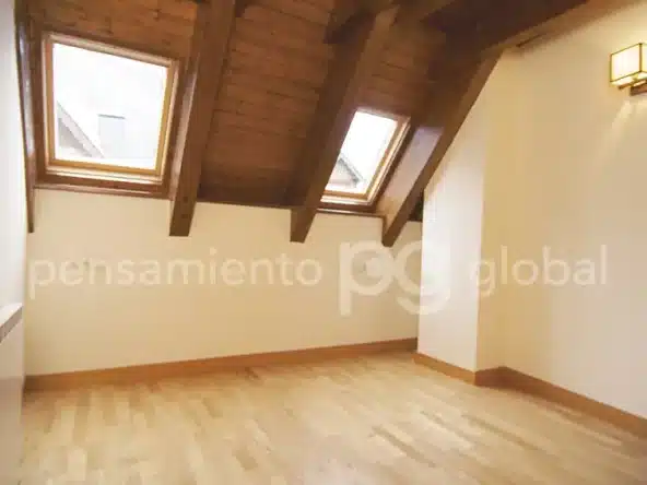 La otra habitación en el segundo piso con techo con vigas y piso de madera.