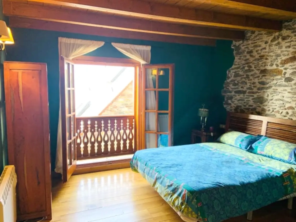 Otro dormitorio igual, dormitorio doble con ventana y vigas de madera en el techo.