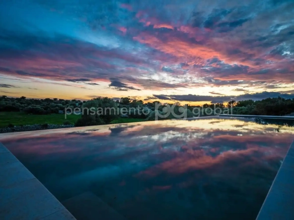 Puesta de sol reflejada en el agua de la piscina.