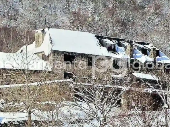 Casa en invierno con nieve en el techo.