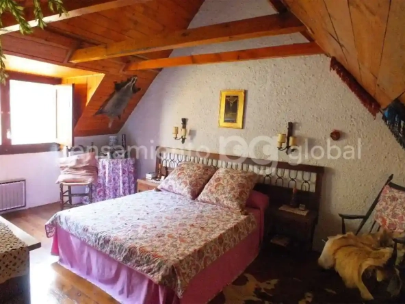 Precioso dormitorio con cama de matrimonio en lo alto de la casa.