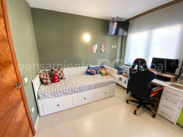 Dormitorio pequeño con lugar para trabajar con ordenador.