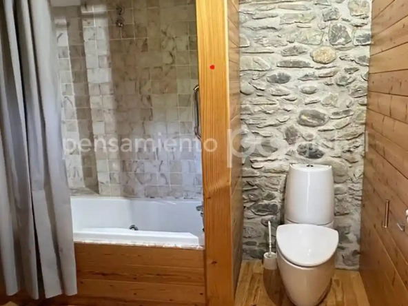 Cuarto de baño con suelo de madera, vigas de madera