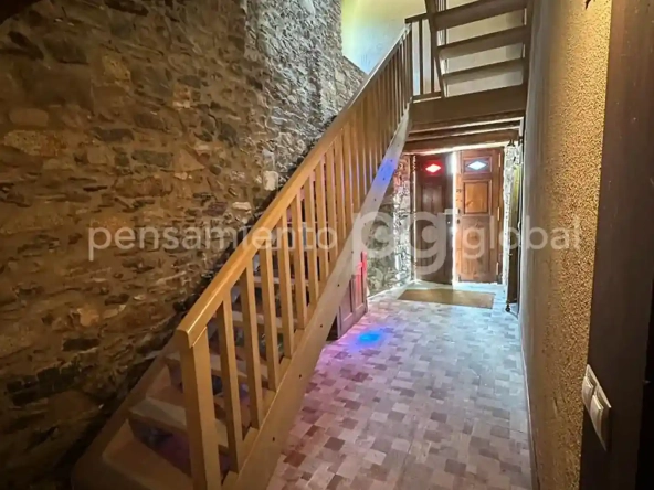 Escaleras de madera contra una pared de piedra.