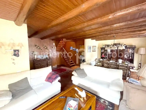 Salón visto desde la zona de sofás con las escaleras de madera al fondo