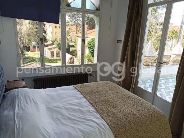 dormitorio principal con salida a la terraza con ventanas en dos paredes