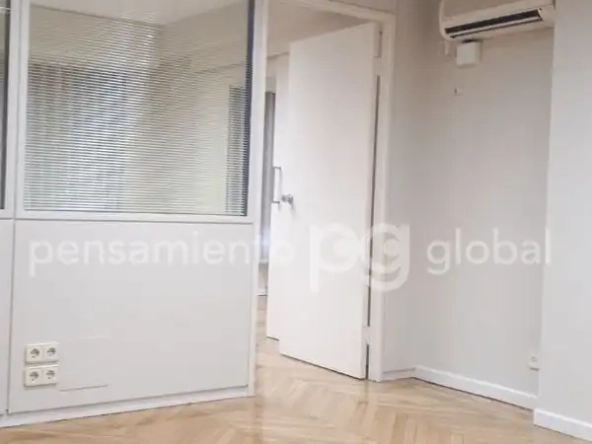 Oficina privada con ventana en pared interna.
